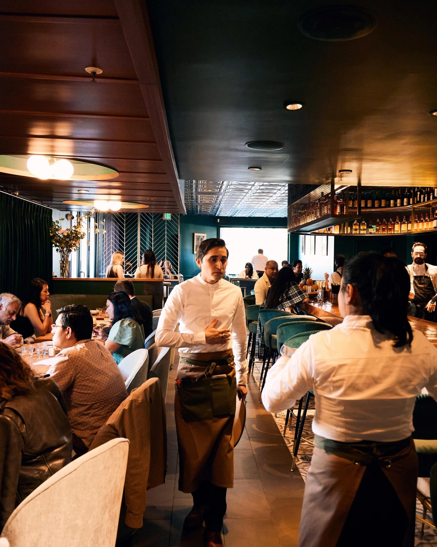 Restaurant staff serving guests in a busy dining room
