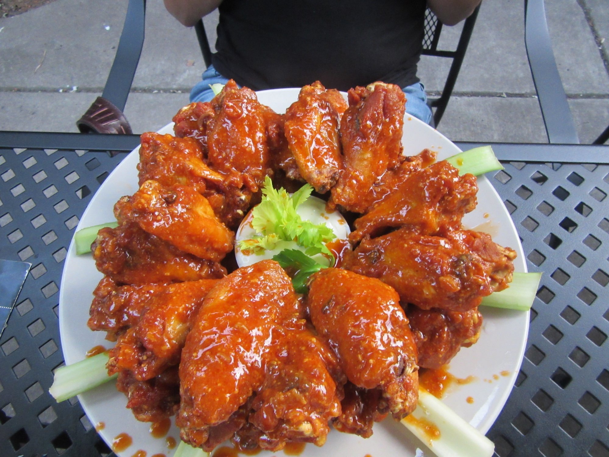Wings arranged around a dip on an outdoor table at Nine-Eleven Tavern