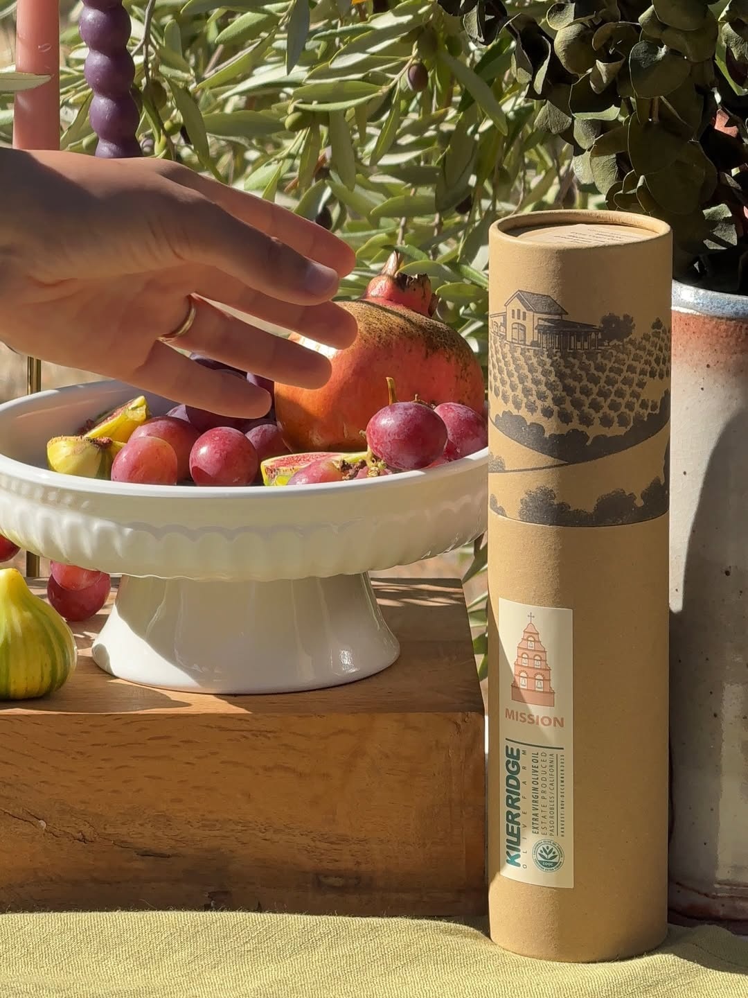 Kiler Ridge Mission olive oil presented beside seasonal fruit and an olive branch