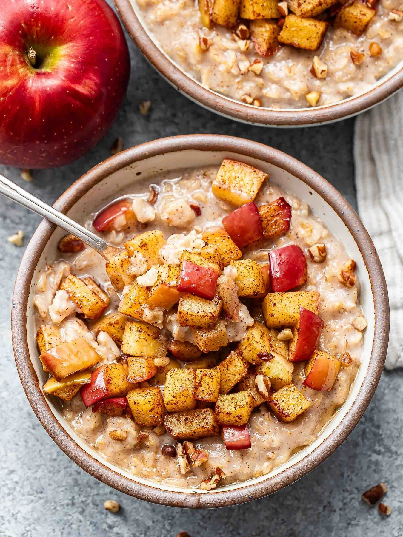 Bowls of creamy oatmeal topped with diced cinnamon apples