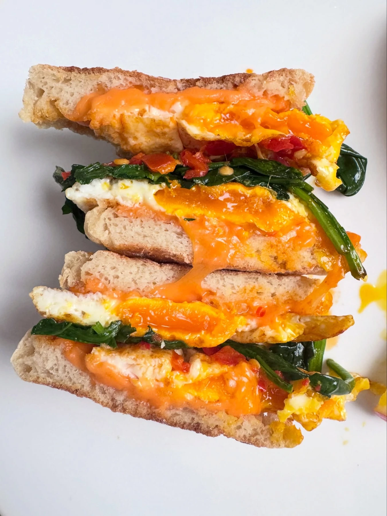 English muffin sandwich with eggs, cheddar, spinach, and chili peppers