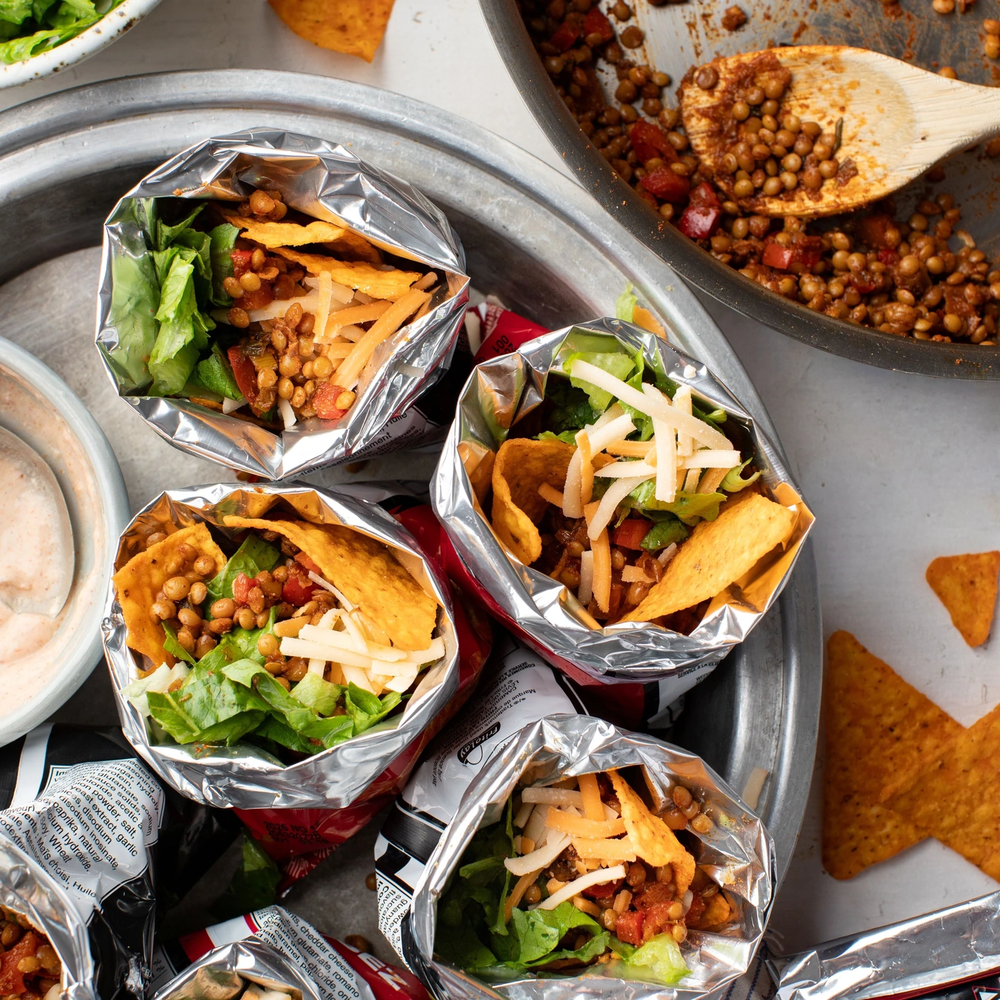 Vegetarian walking tacos with corn chips, cheese, and greens