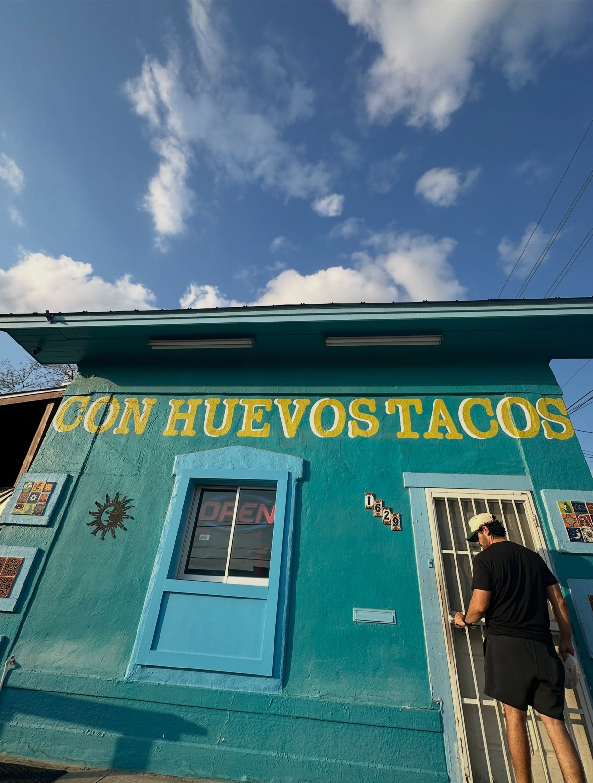 The turquoise Con Huevos Tacos building and order window on East Houston Street