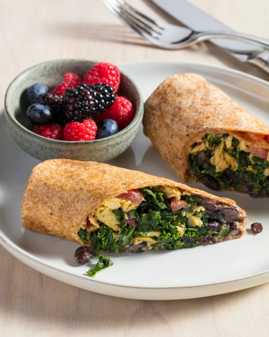 Egg and black bean breakfast burritos served with fresh berries
