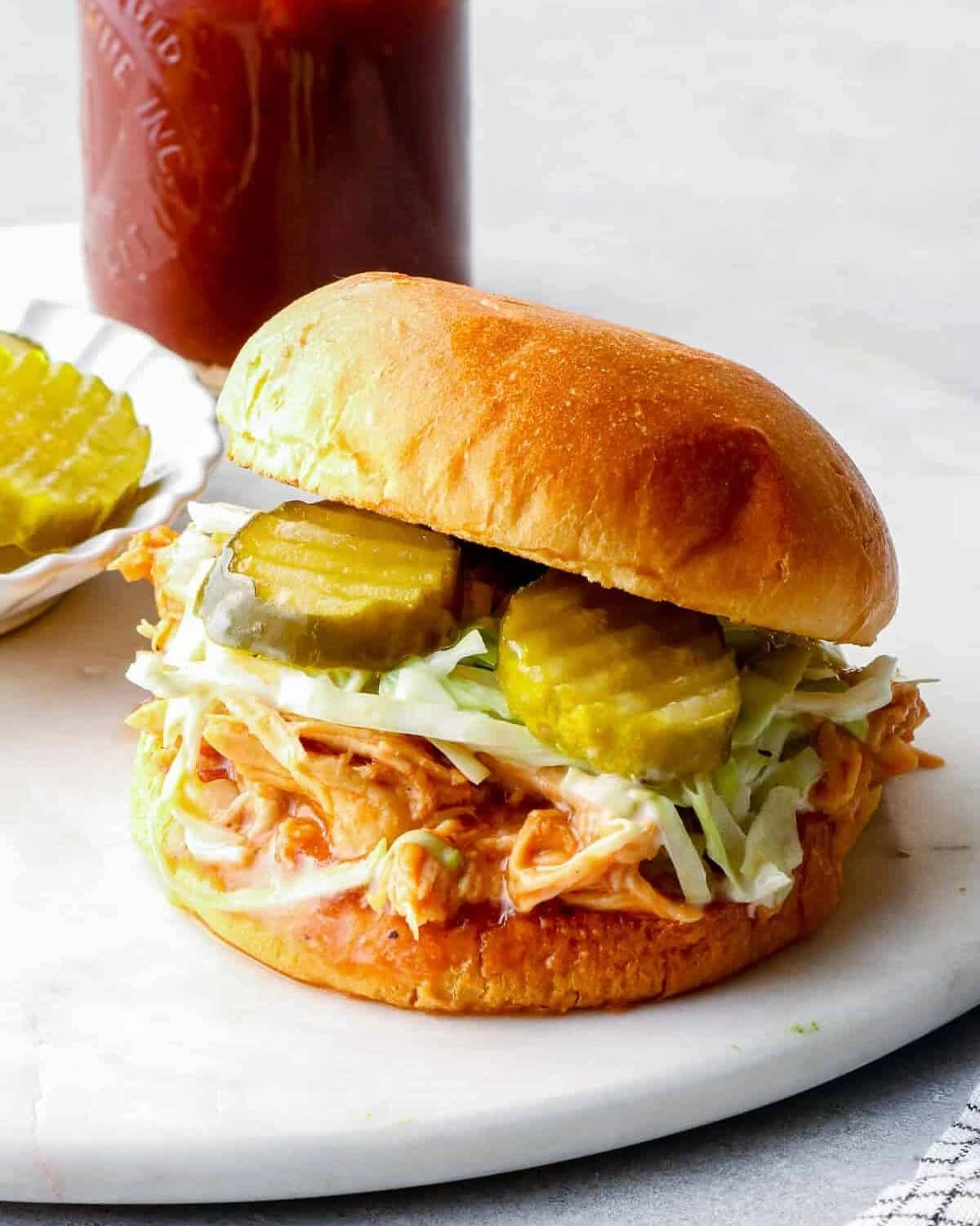 Pulled barbecue chicken sandwich with cabbage slaw and pickles