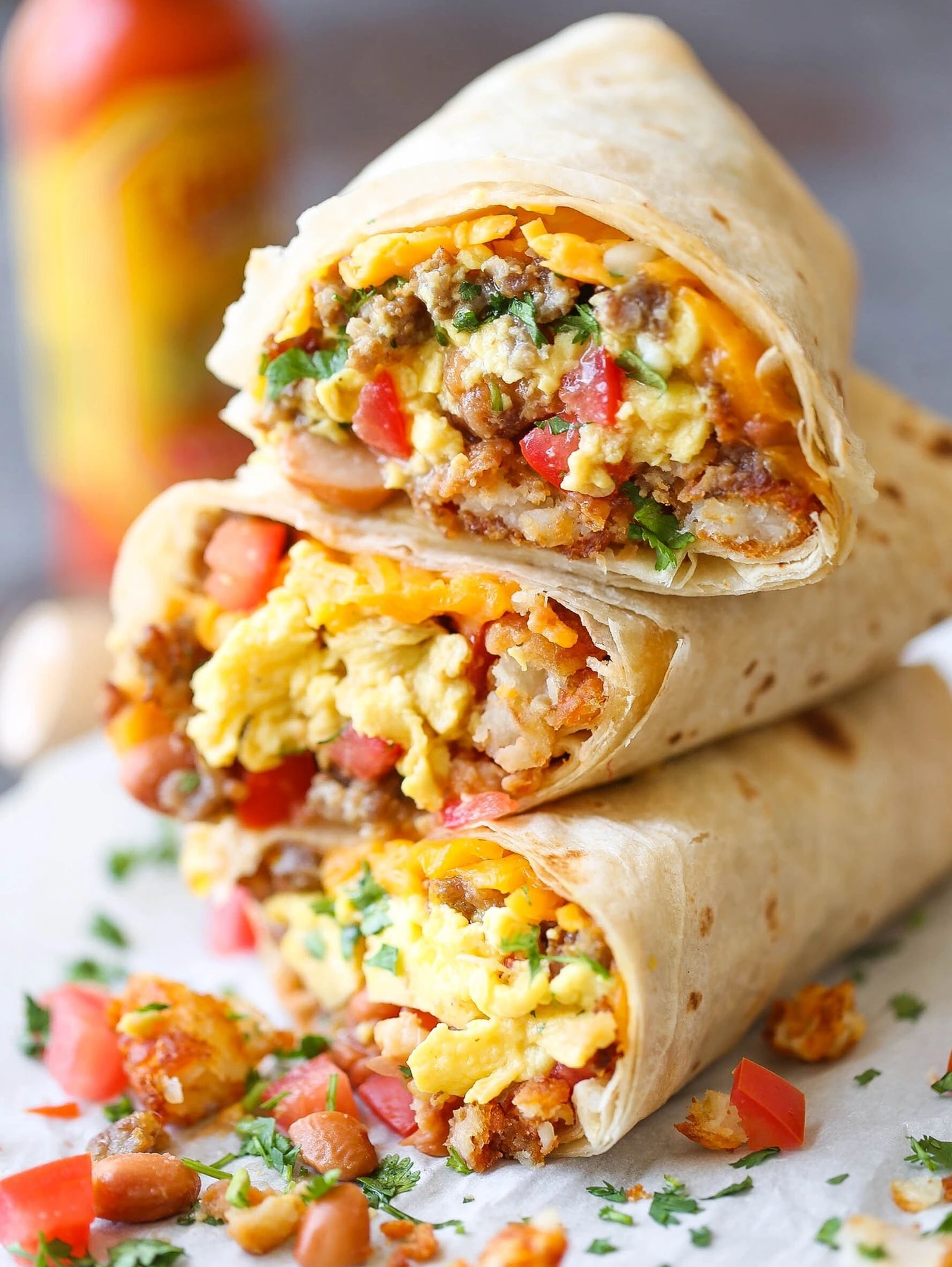 Stacked breakfast burritos filled with eggs, beans, potatoes and cheese