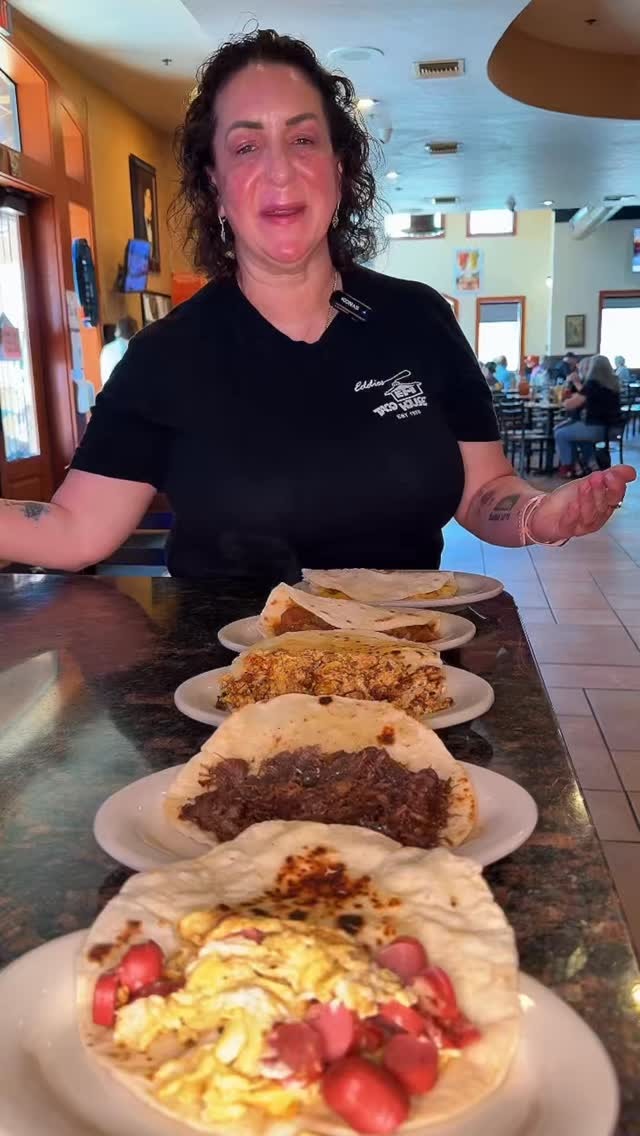 An Eddie’s Taco House staff member presenting a selection of breakfast tacos