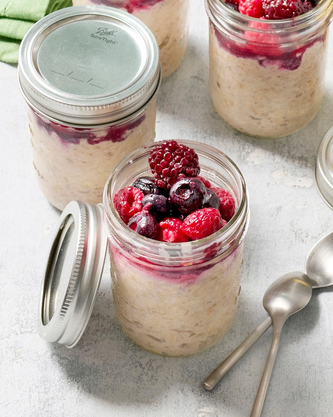 Overnight oats with berries in screw-top glass jars