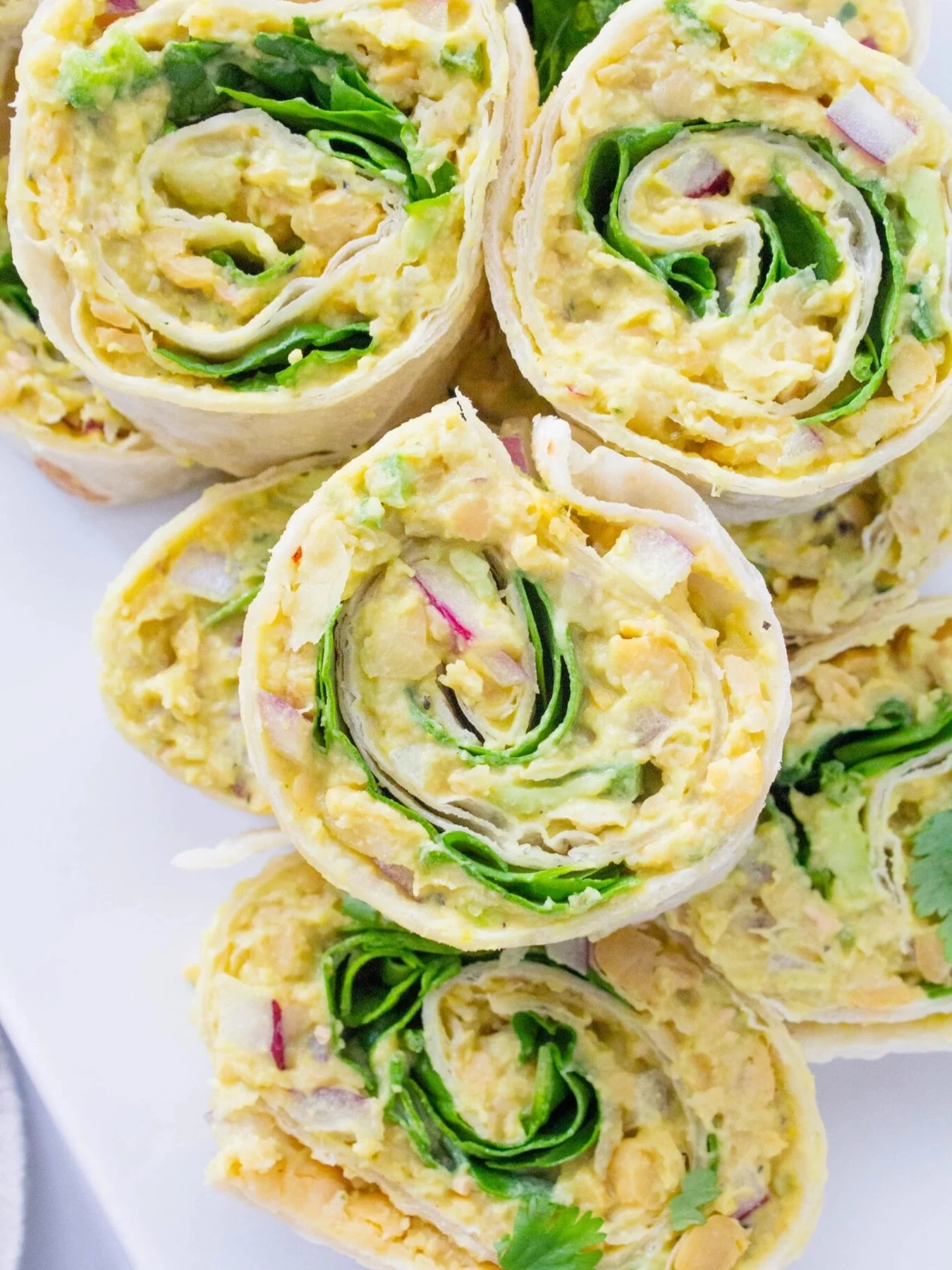 Small chickpea salad pinwheels with lettuce and diced red onion