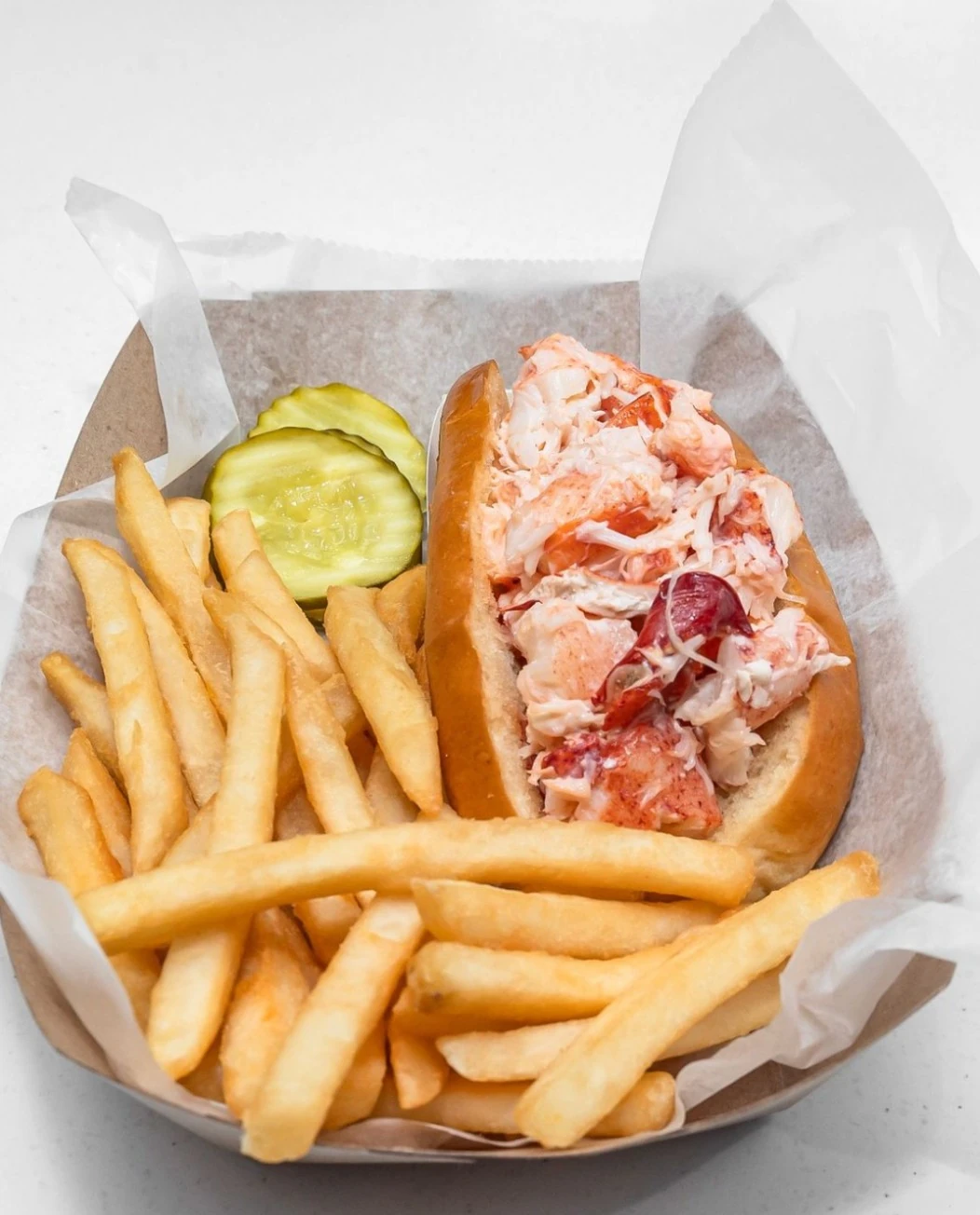 Lobster roll with fries and pickle slices at Bob’s Clam Hut in Kittery