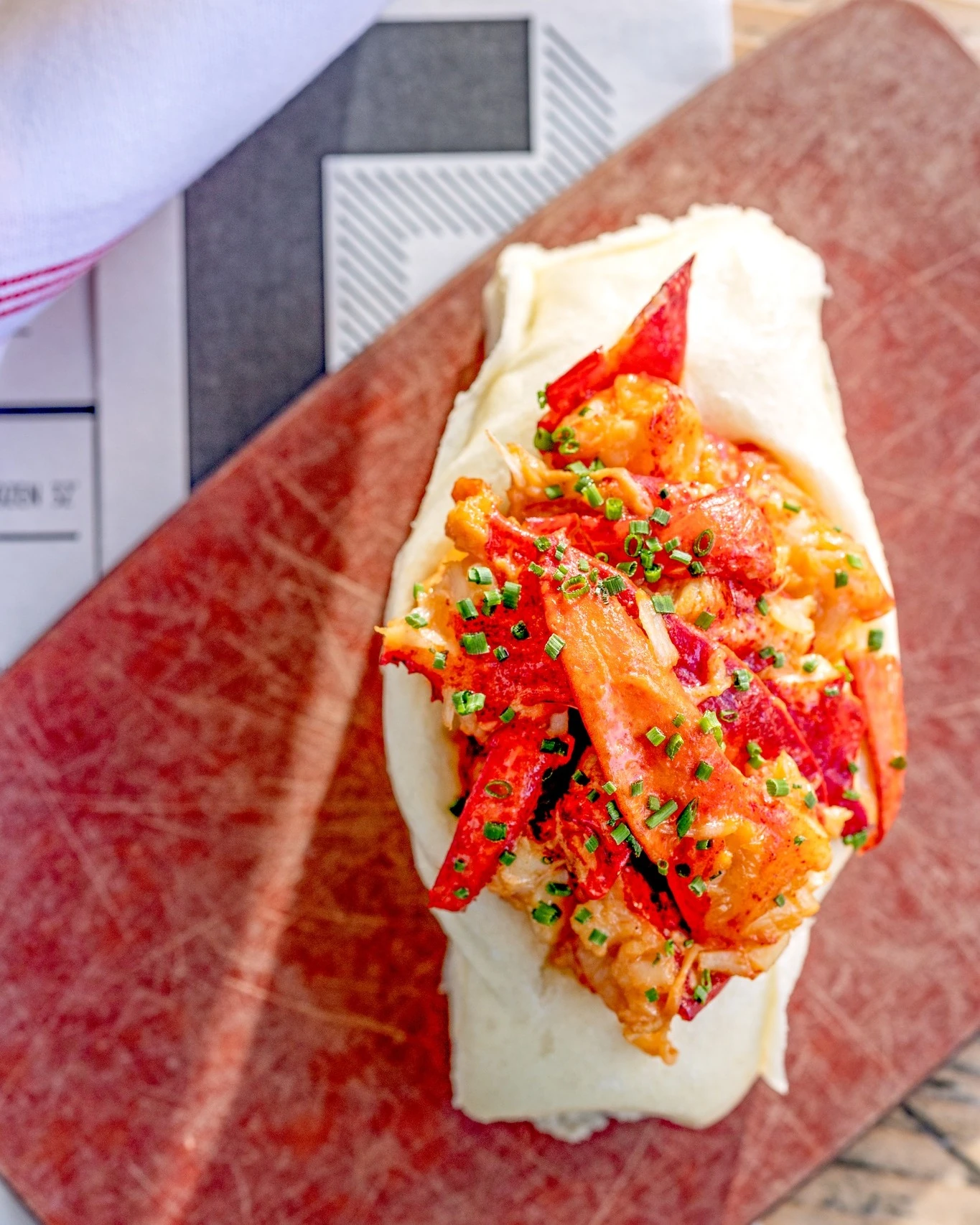 Eventide’s brown-butter lobster roll in a steamed bun with chives
