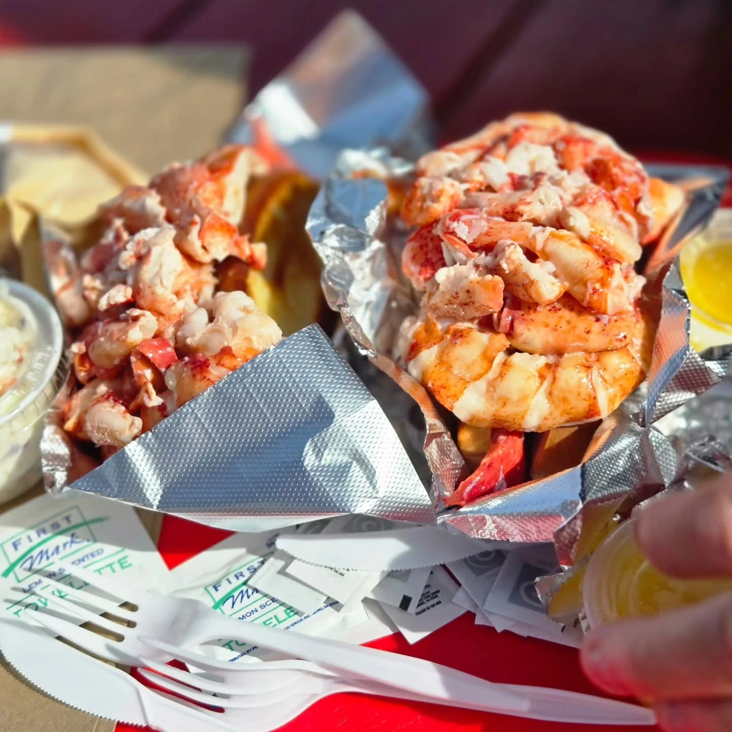 Two generously filled lobster rolls in foil at Red’s Eats in Wiscasset