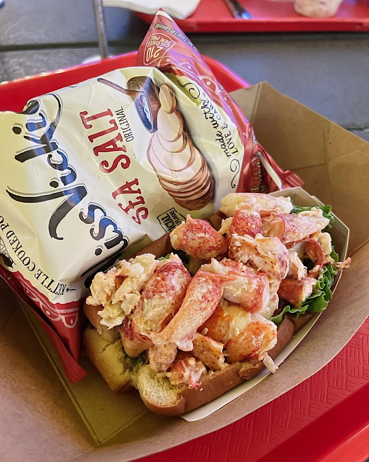 Thurston’s lobster roll on lettuce with potato chips on a red tray