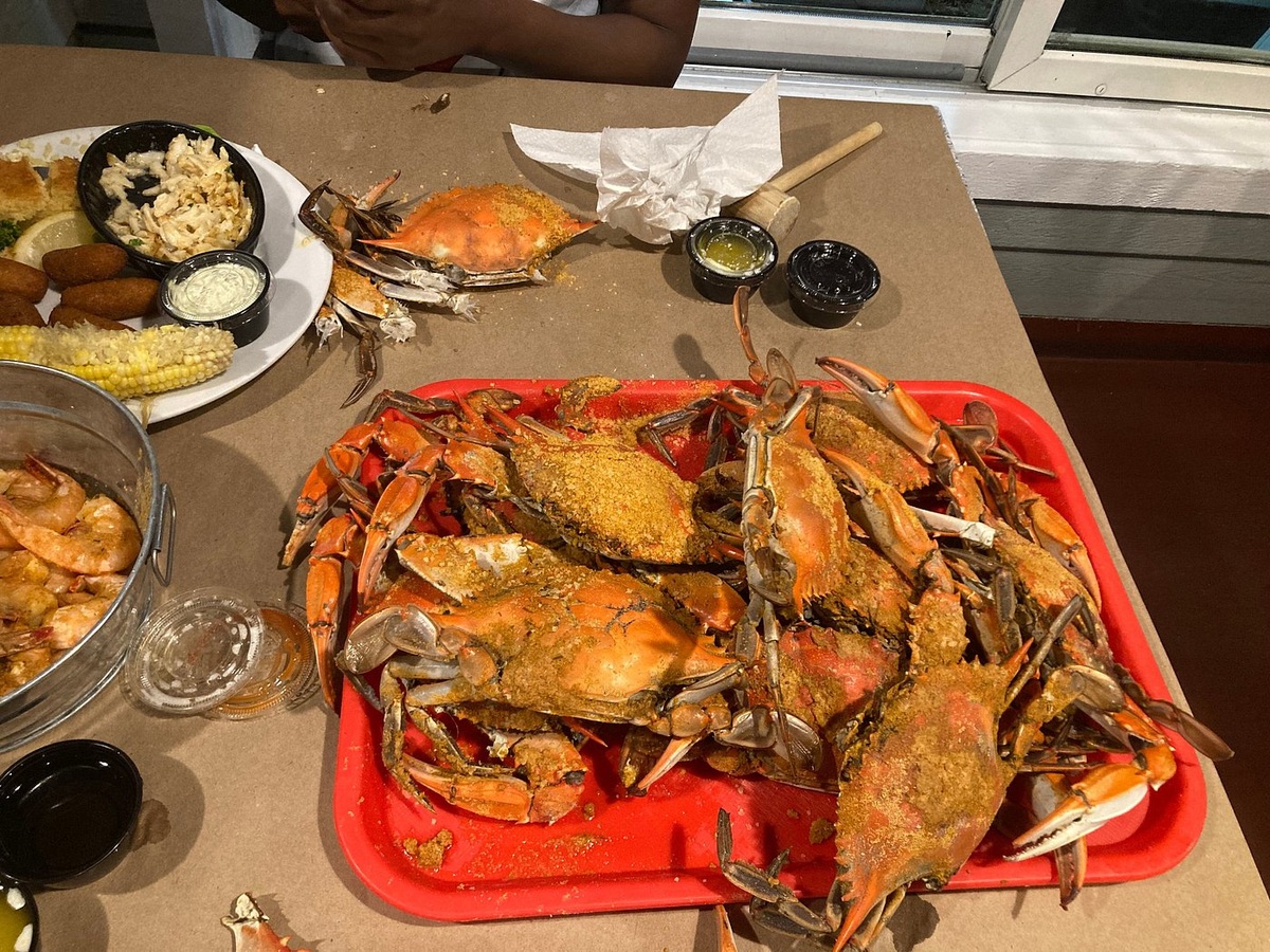 Whole crabs, corn and sides on a paper-covered table at Harris Crab House
