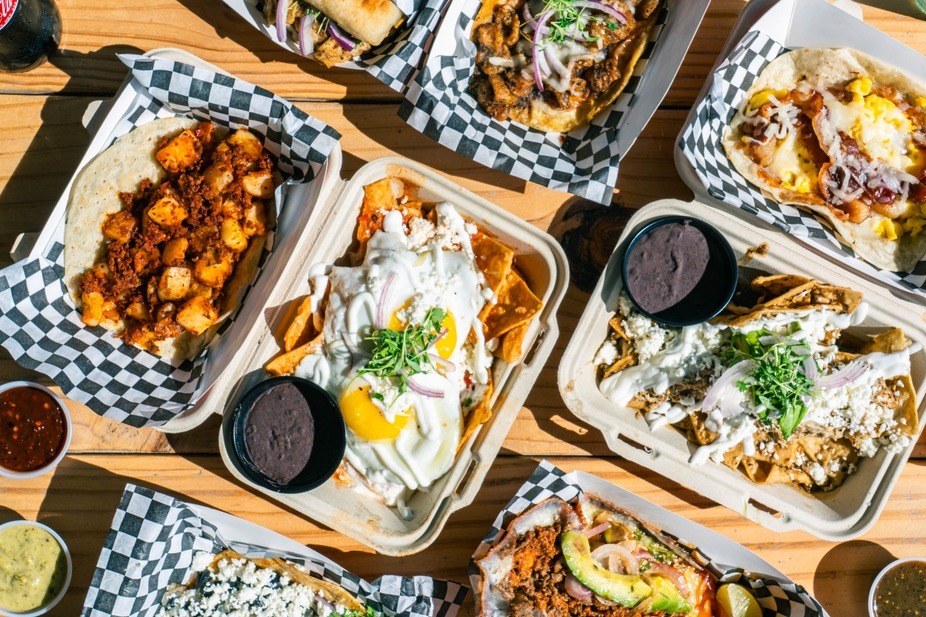 Chilaquiles and other dishes arranged on a table at Naco Mexican
