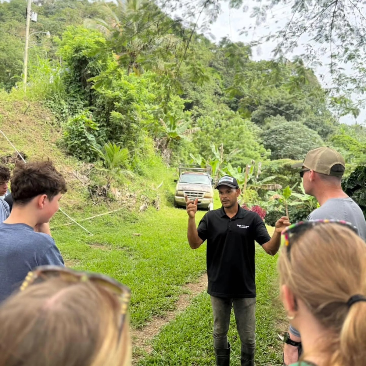 A guide explains coffee cultivation to visitors at Hacienda Encanto Natural