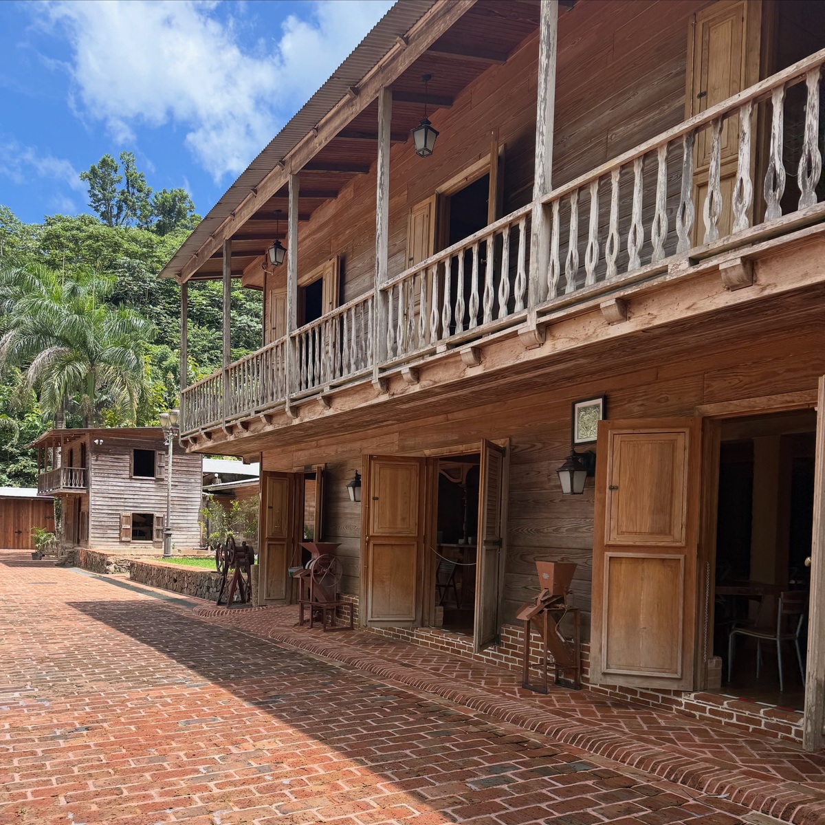 Restored wooden buildings and brick courtyard at Hacienda Lealtad in Lares
