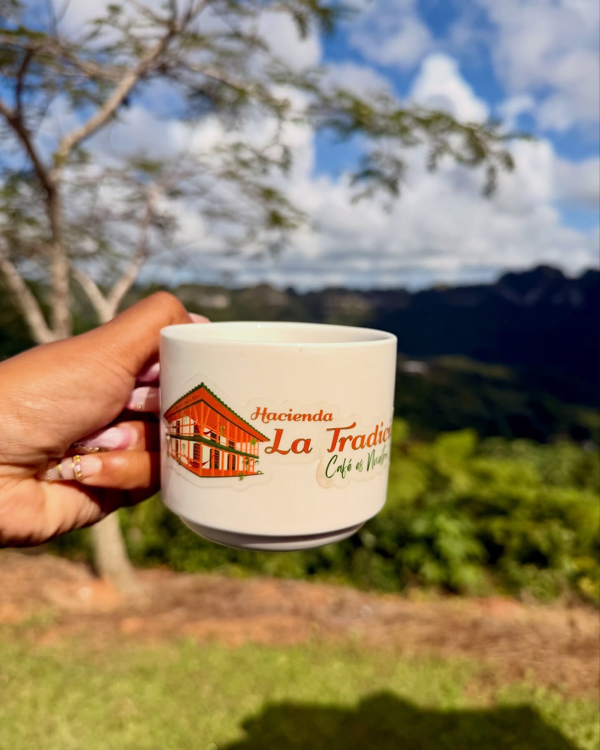 A cup of Hacienda La Tradición coffee overlooking the mountains of Utuado