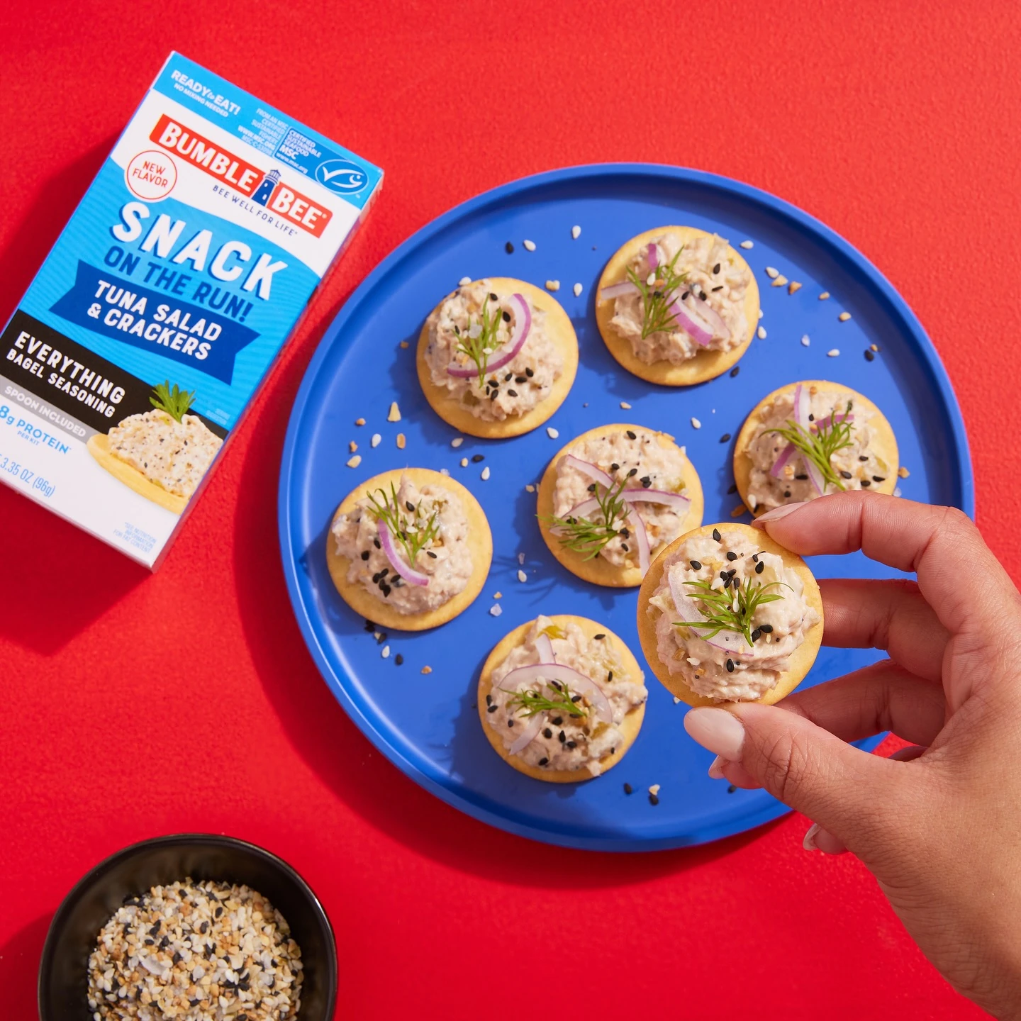 Tuna and cracker snack kit with tuna-topped crackers on a blue plate