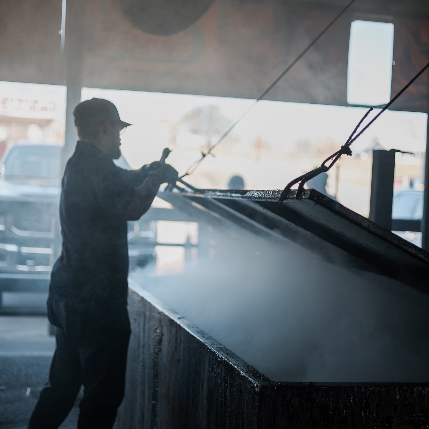 A pit worker tending the smokers at Cooper’s in Llano
