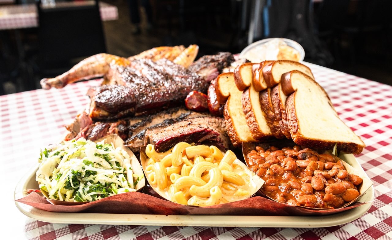 A barbecue tray with bread and sides at Goldee’s