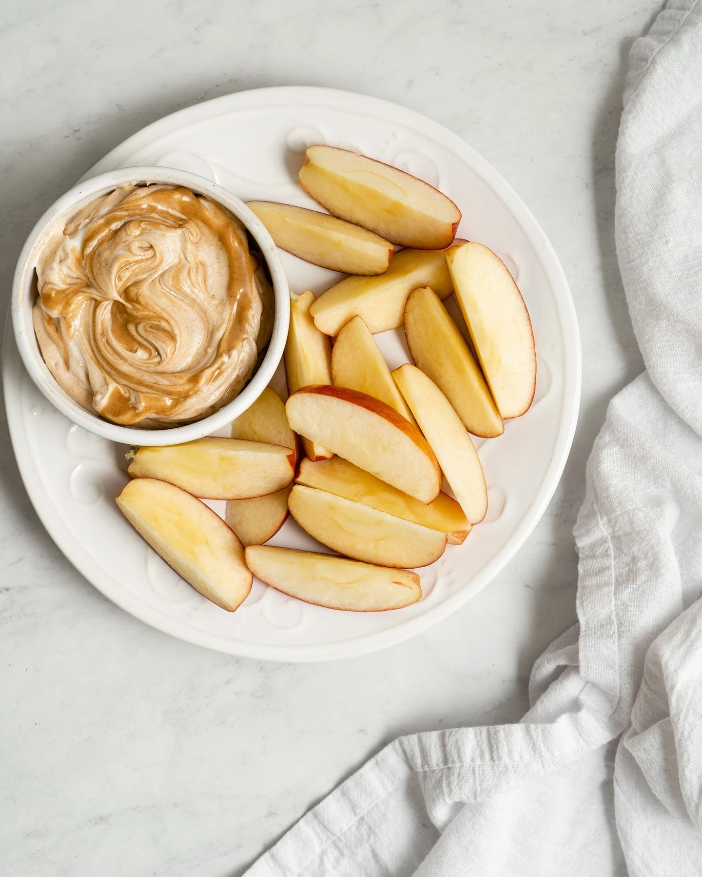 Apple slices served with a bowl of peanut butter dip