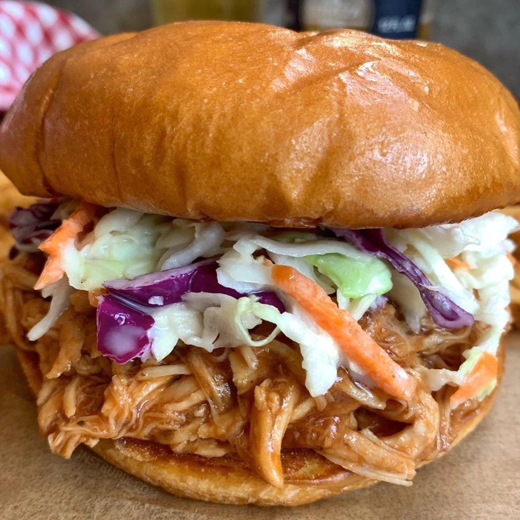 Shredded barbecue chicken sandwich with coleslaw in a toasted bun