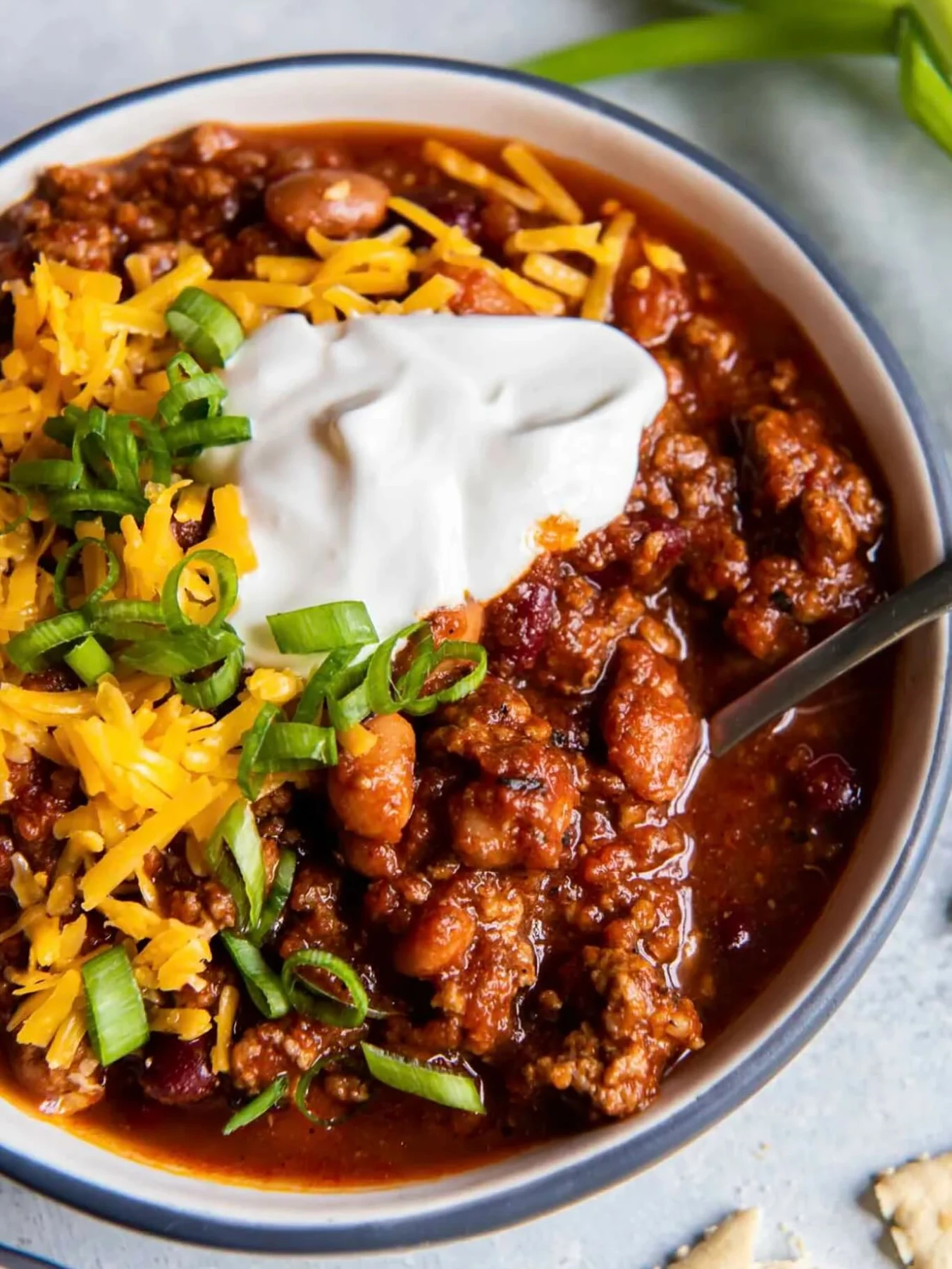 Beef and bean chili topped with cheese, sour cream and green onions