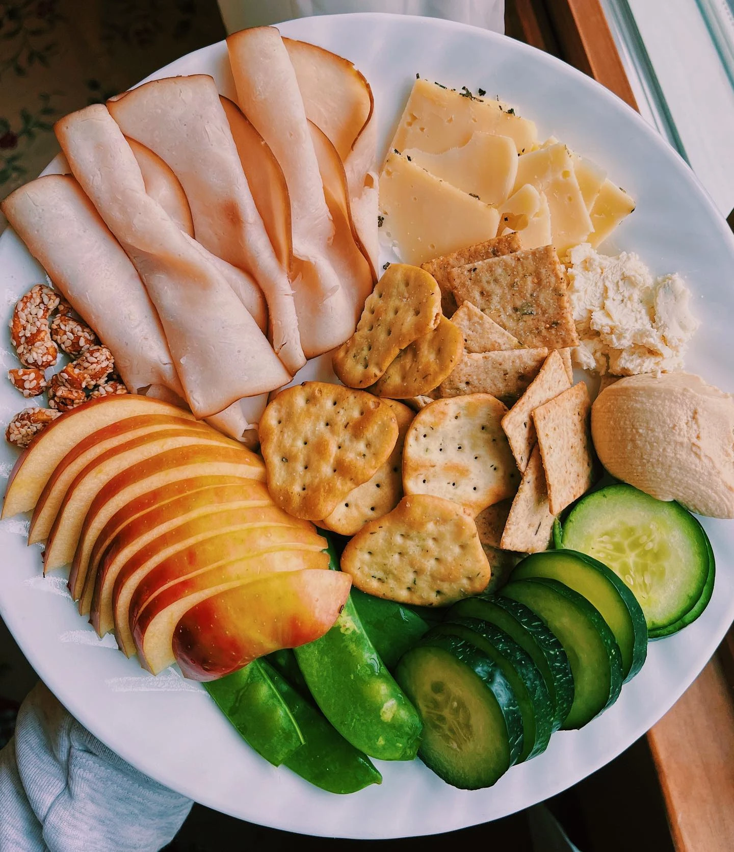 Apple slices, cheese, crackers and vegetables on a snack plate