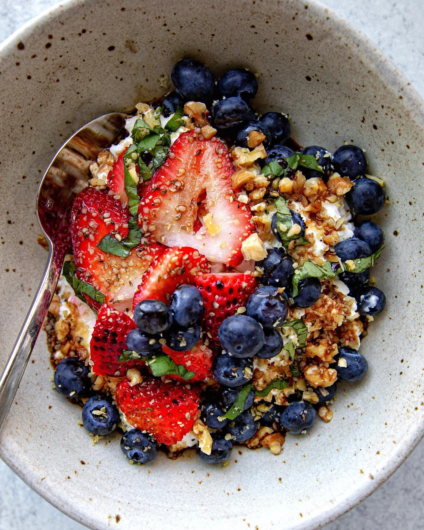 Cottage cheese topped with sliced strawberries, blueberries and chopped walnuts
