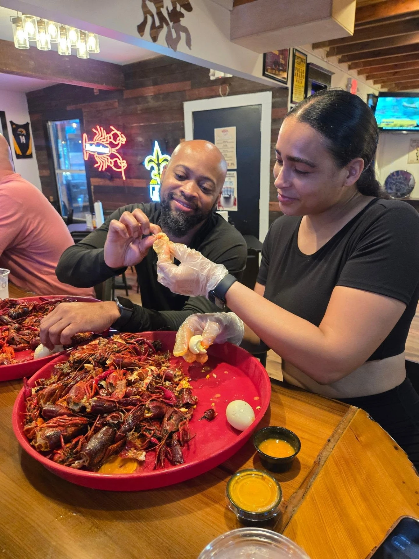 Diners peel boiled crawfish from large trays at Clesi’s in New Orleans