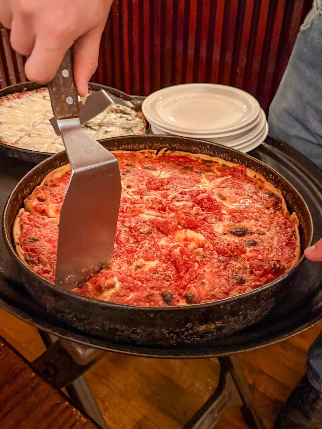 Deep-dish pizza being served from its pan at Lou Malnati’s