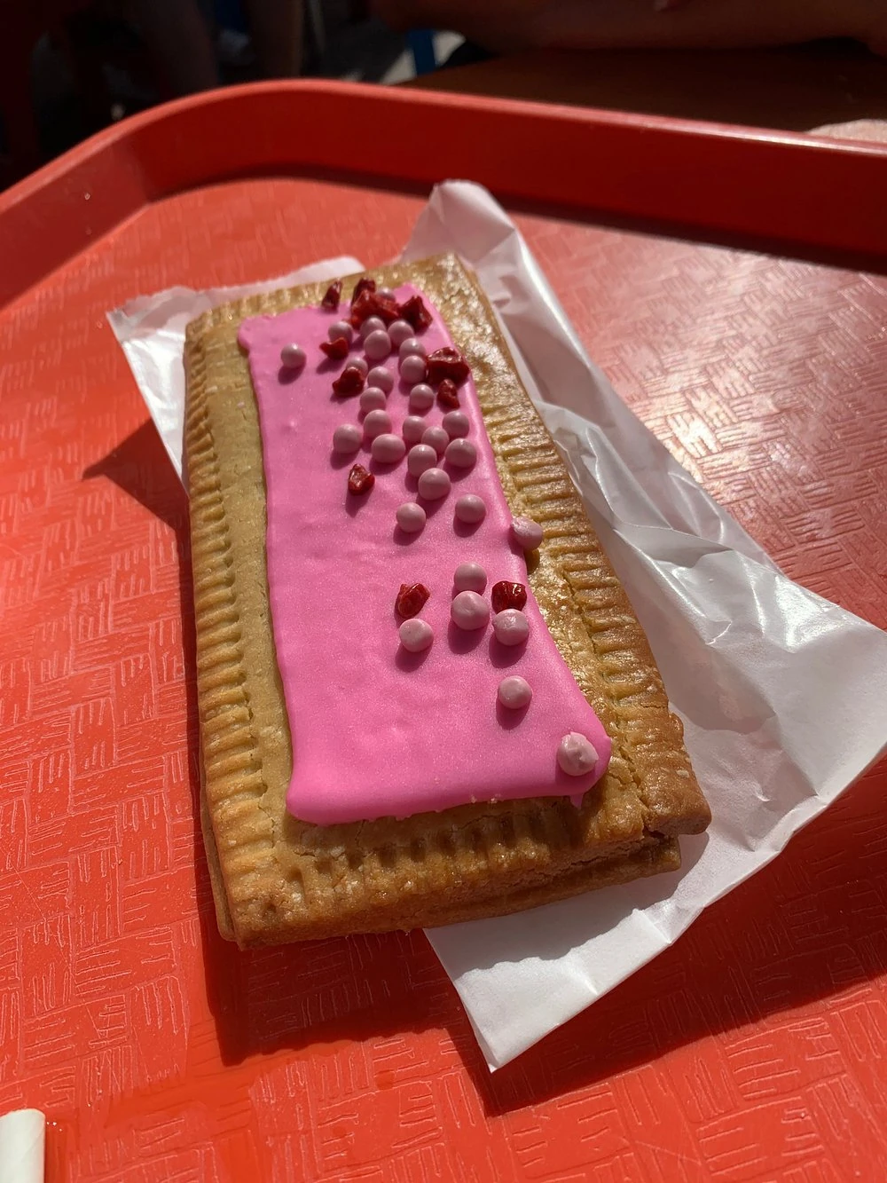 Raspberry Lunch Box Tart with pink icing and sprinkles at Woody’s Lunch Box