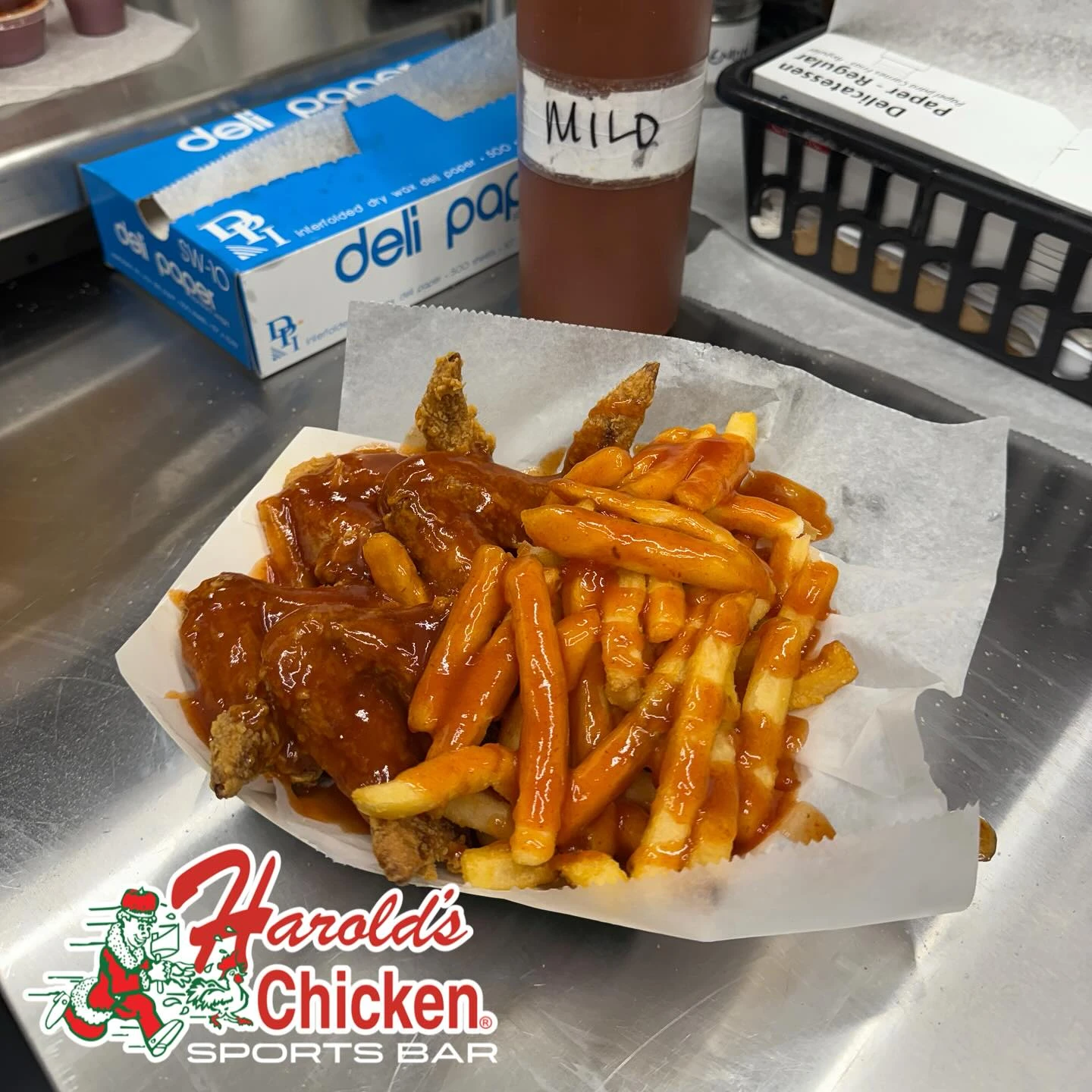 Fried chicken wings and fries covered in Harold’s mild sauce