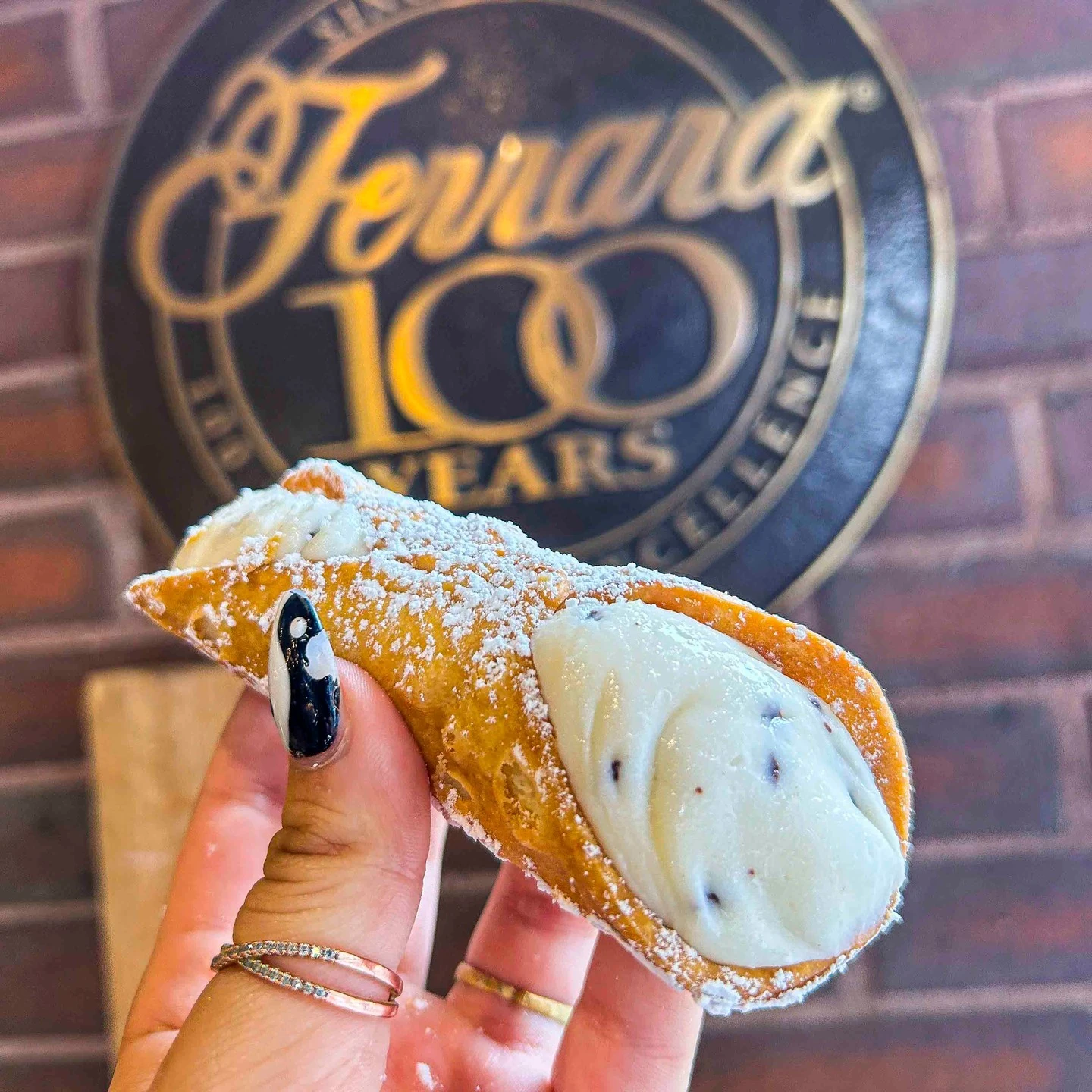 Ricotta-filled cannoli dusted with powdered sugar at Ferrara Bakery in Little Italy