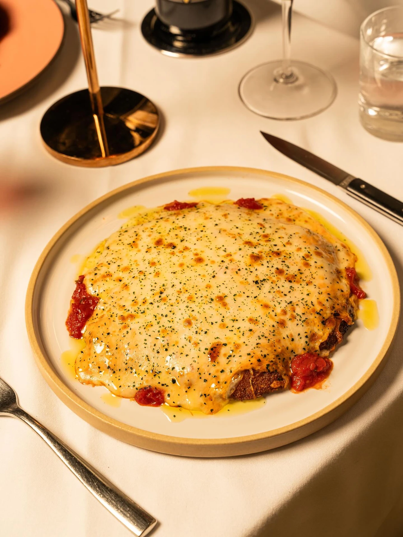 Chicken Parmesan covered with tomato sauce and melted cheese at Tucci in New York