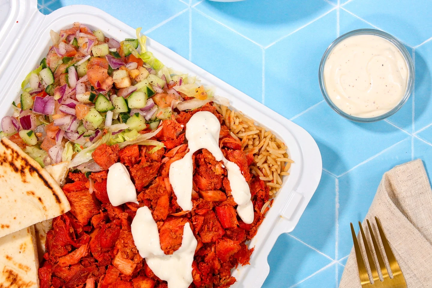 New York chicken over seasoned rice with salad, pita and white sauce