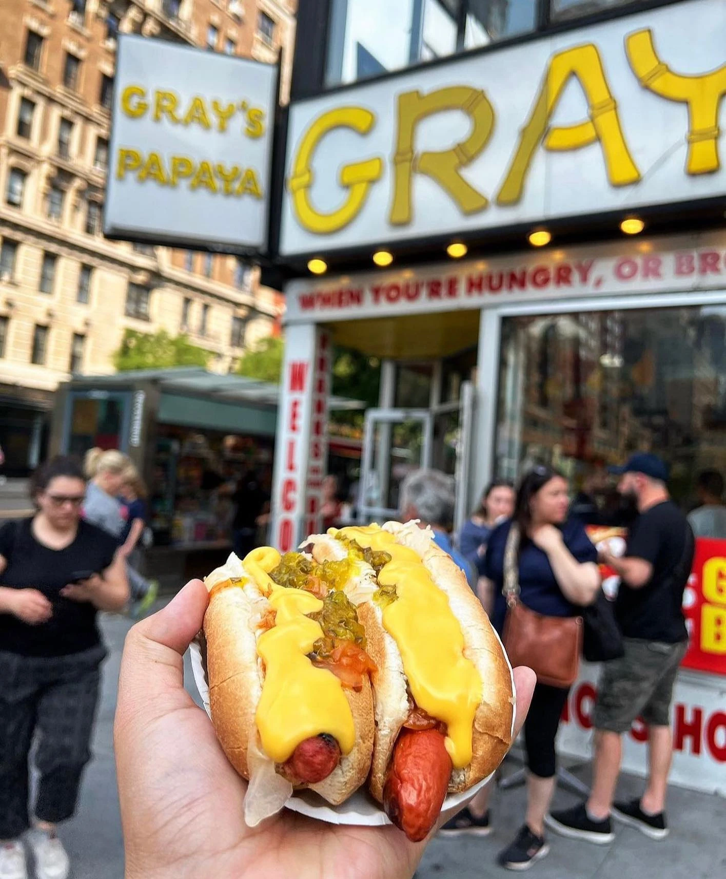 Two topped New York hot dogs outside Gray’s Papaya
