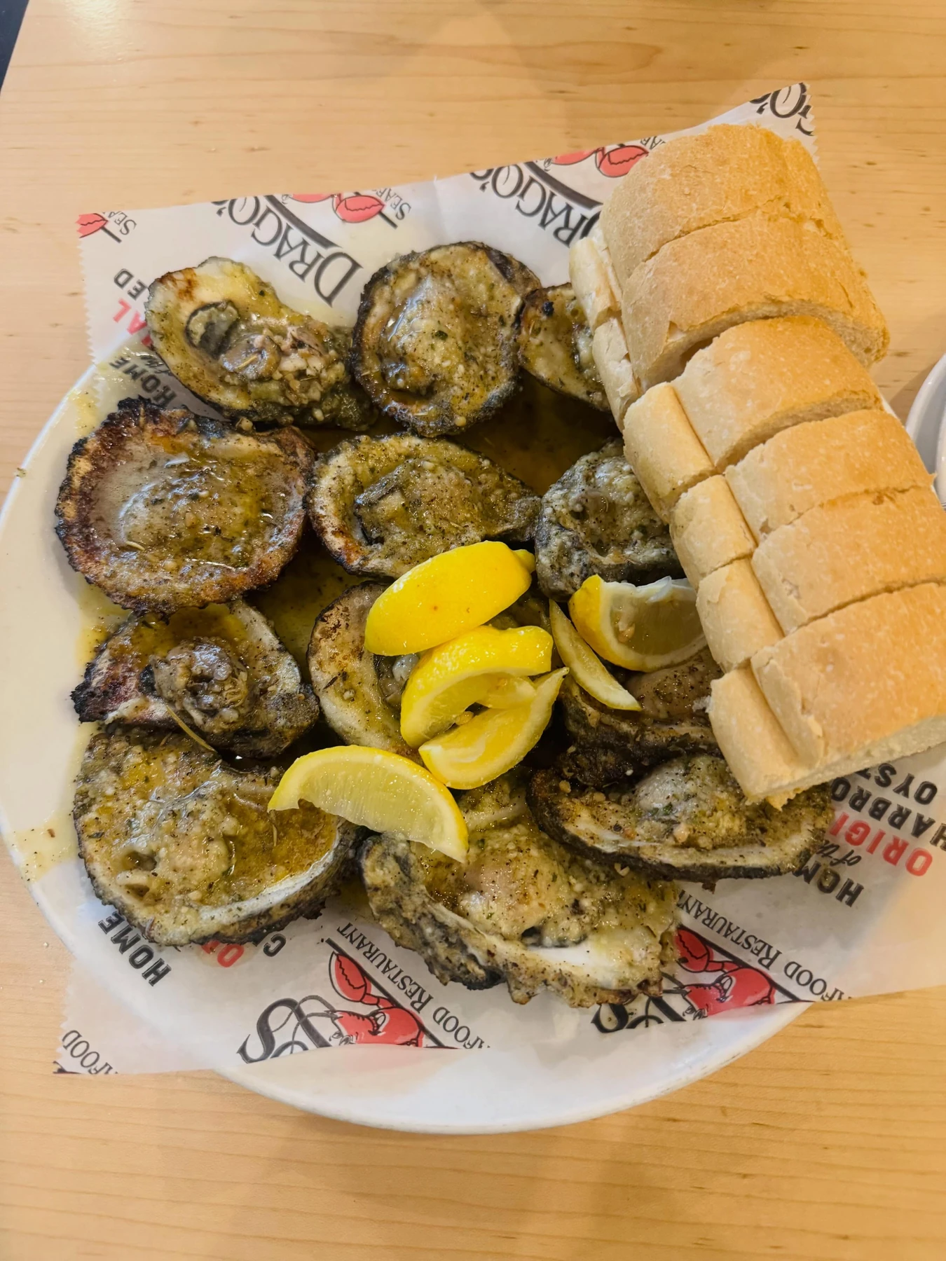Charbroiled oysters with lemon wedges and French bread at Drago’s