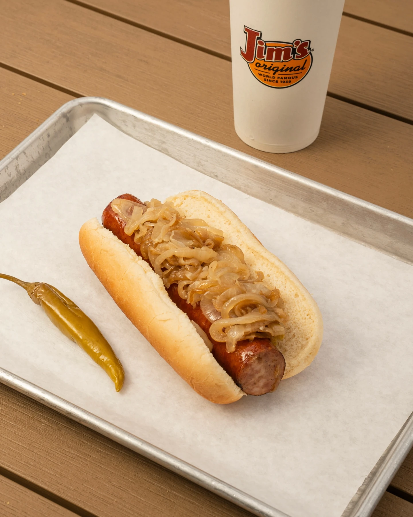 Polish sausage topped with grilled onions, with a sport pepper alongside