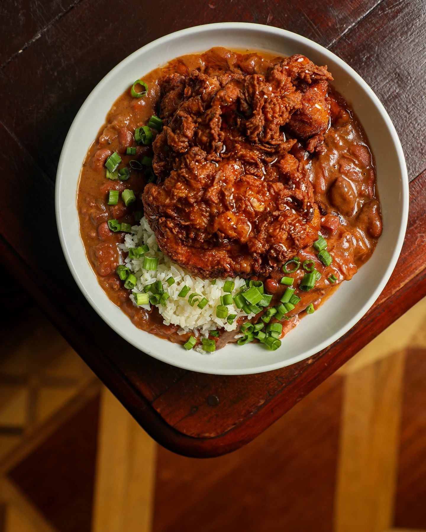 Red beans and rice with fried chicken and sliced green onion at Luke