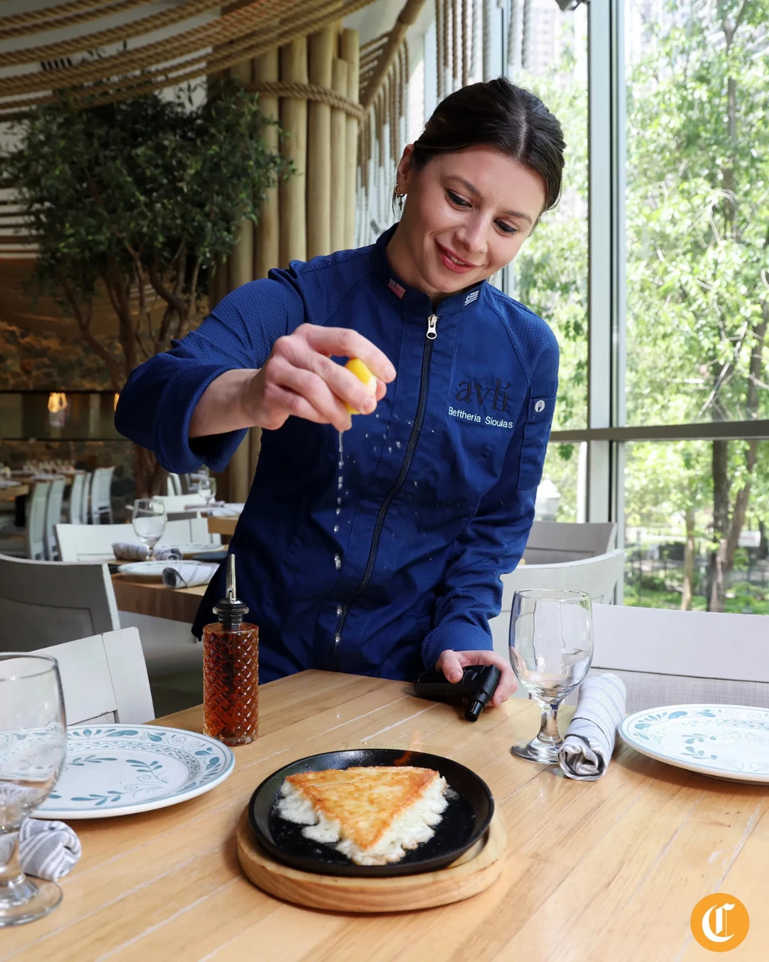 Chef Eleftheria Sioulas finishes saganaki with lemon at Avli on The Park
