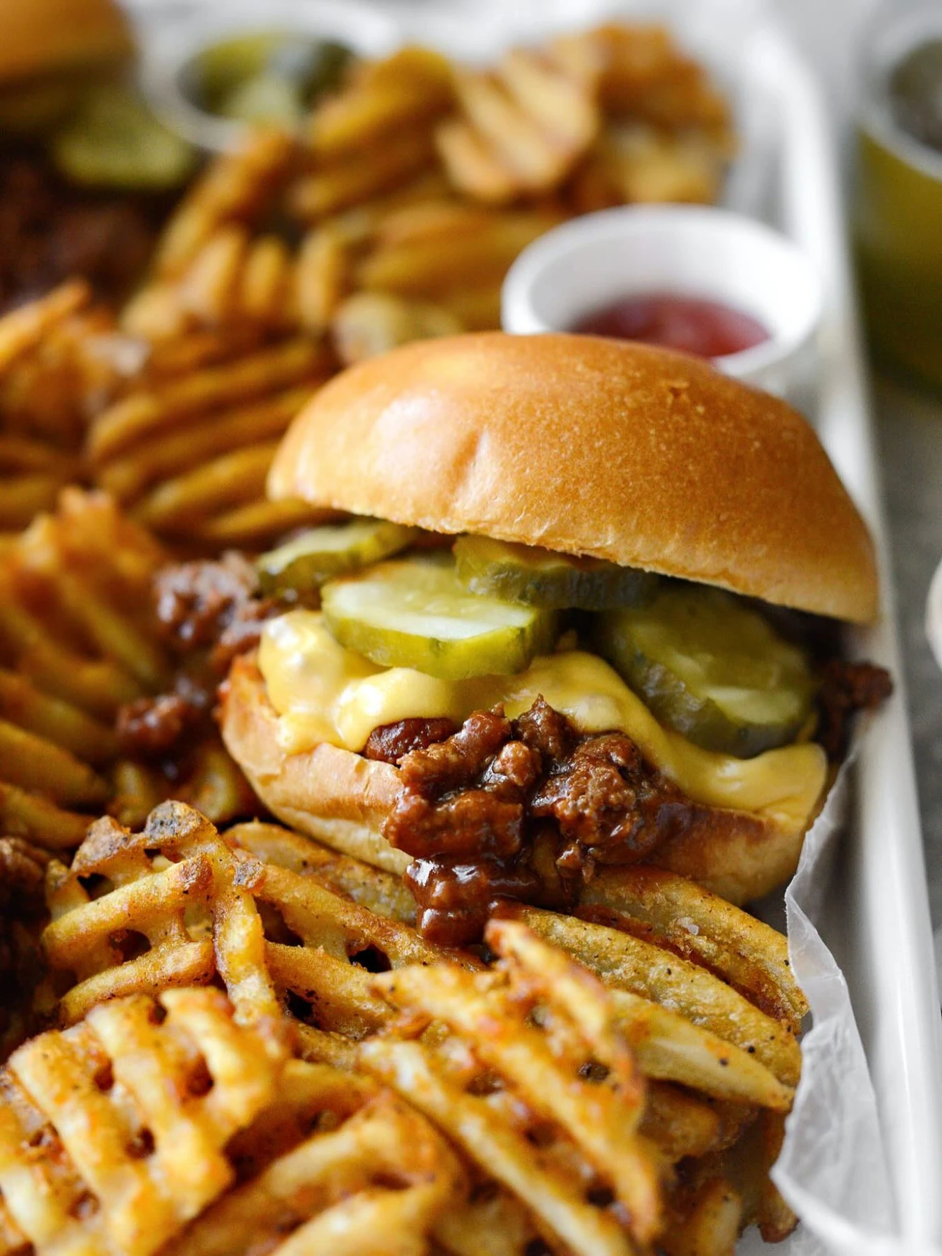 Ground beef sloppy joe on a bun with cheese and pickles