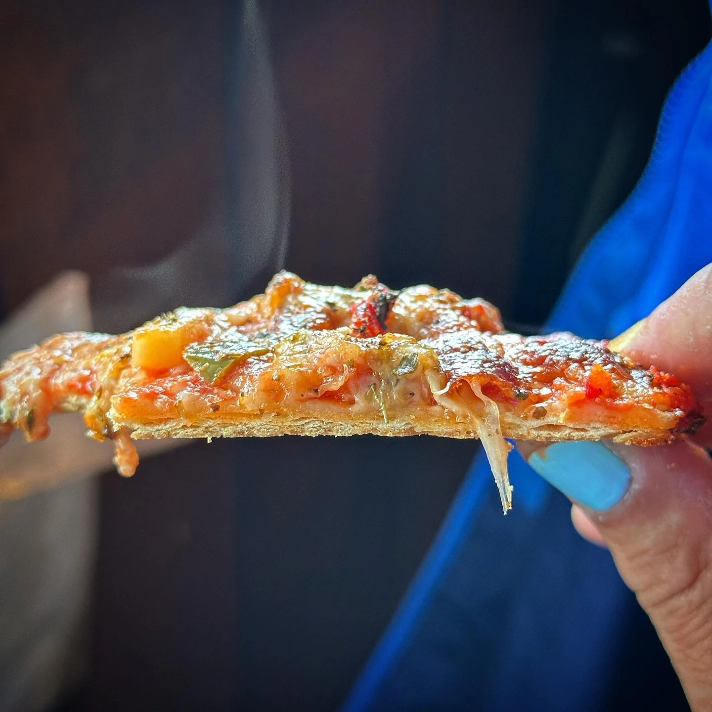 Close-up of a thin, crisp tavern-style pizza slice at Vito and Nick’s