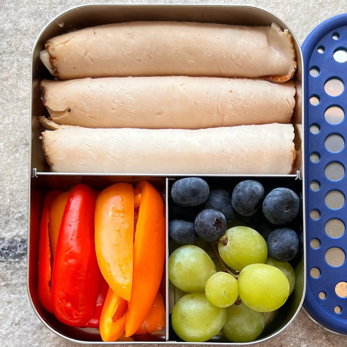 Turkey and provolone roll-ups packed with bell pepper strips, grapes and blueberries