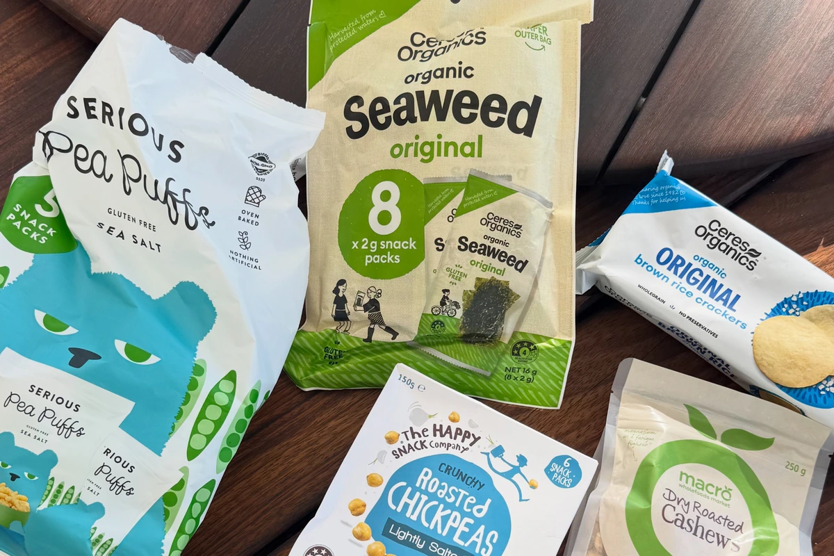 Packed travel snacks including rice crackers, seaweed, cashews and roasted chickpeas