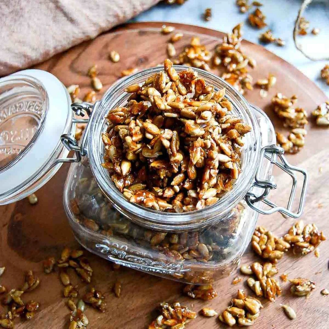 Roasted sunflower kernels in a small clip-top glass jar