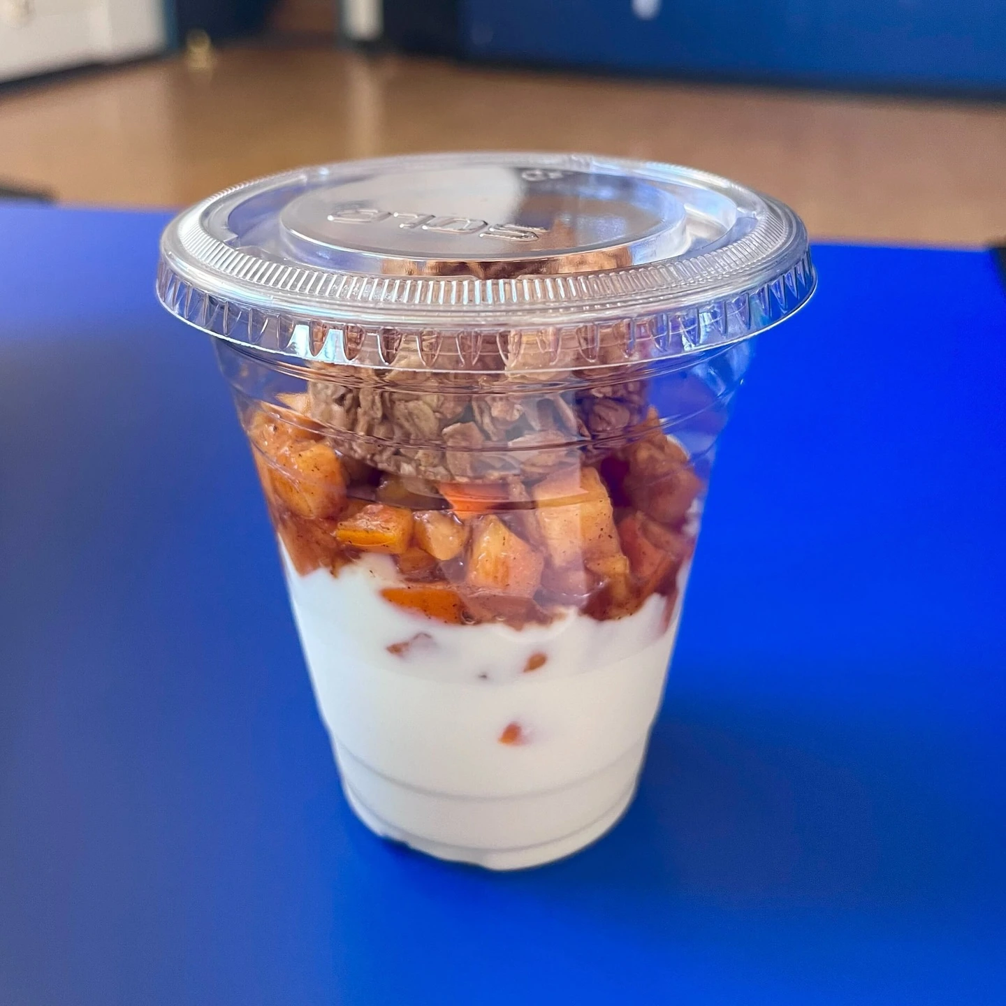 Yogurt and fruit in a portable cup with granola held in a separate top compartment