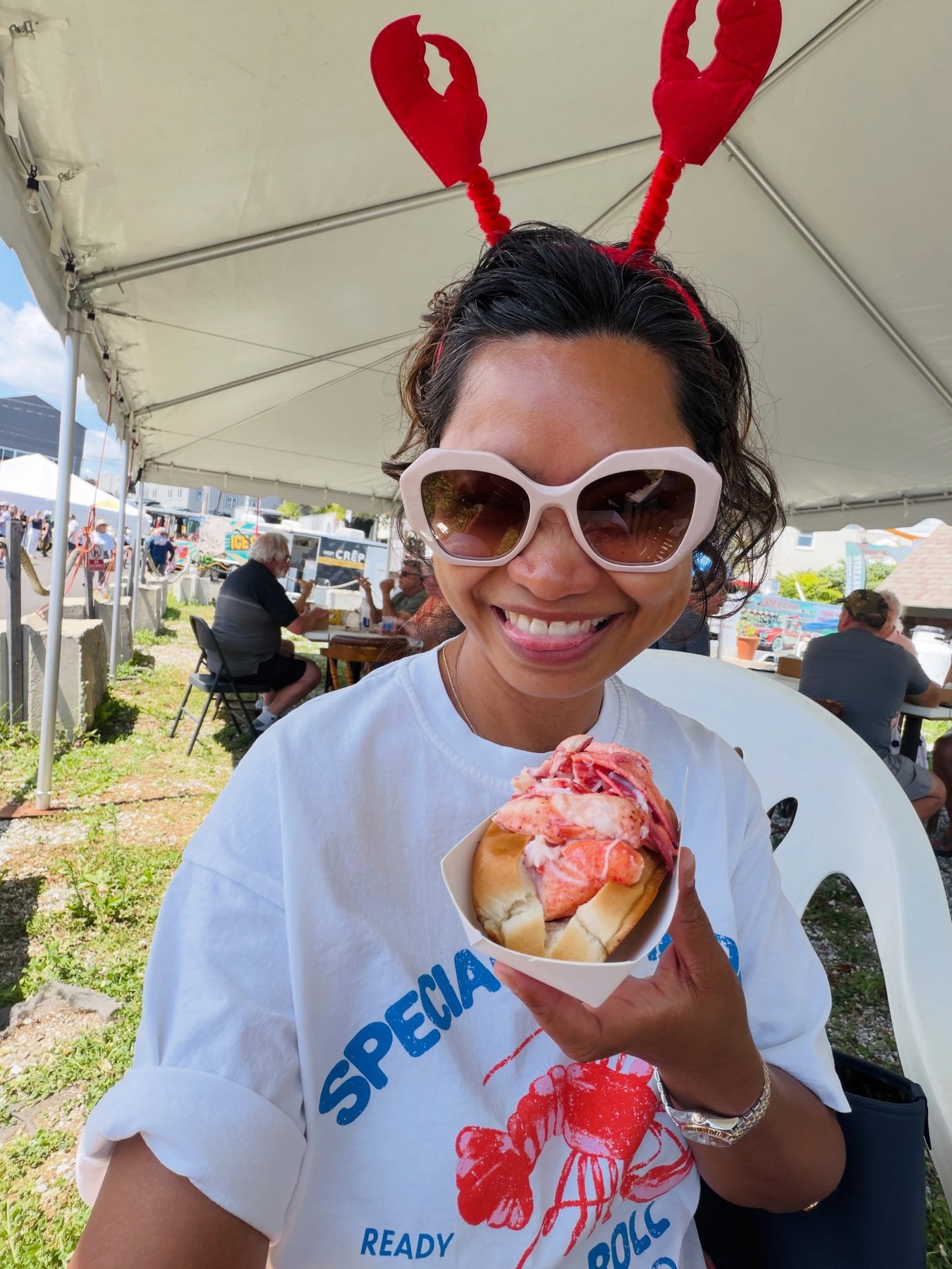 A visitor holding a lobster roll at the Maine Lobster Festival