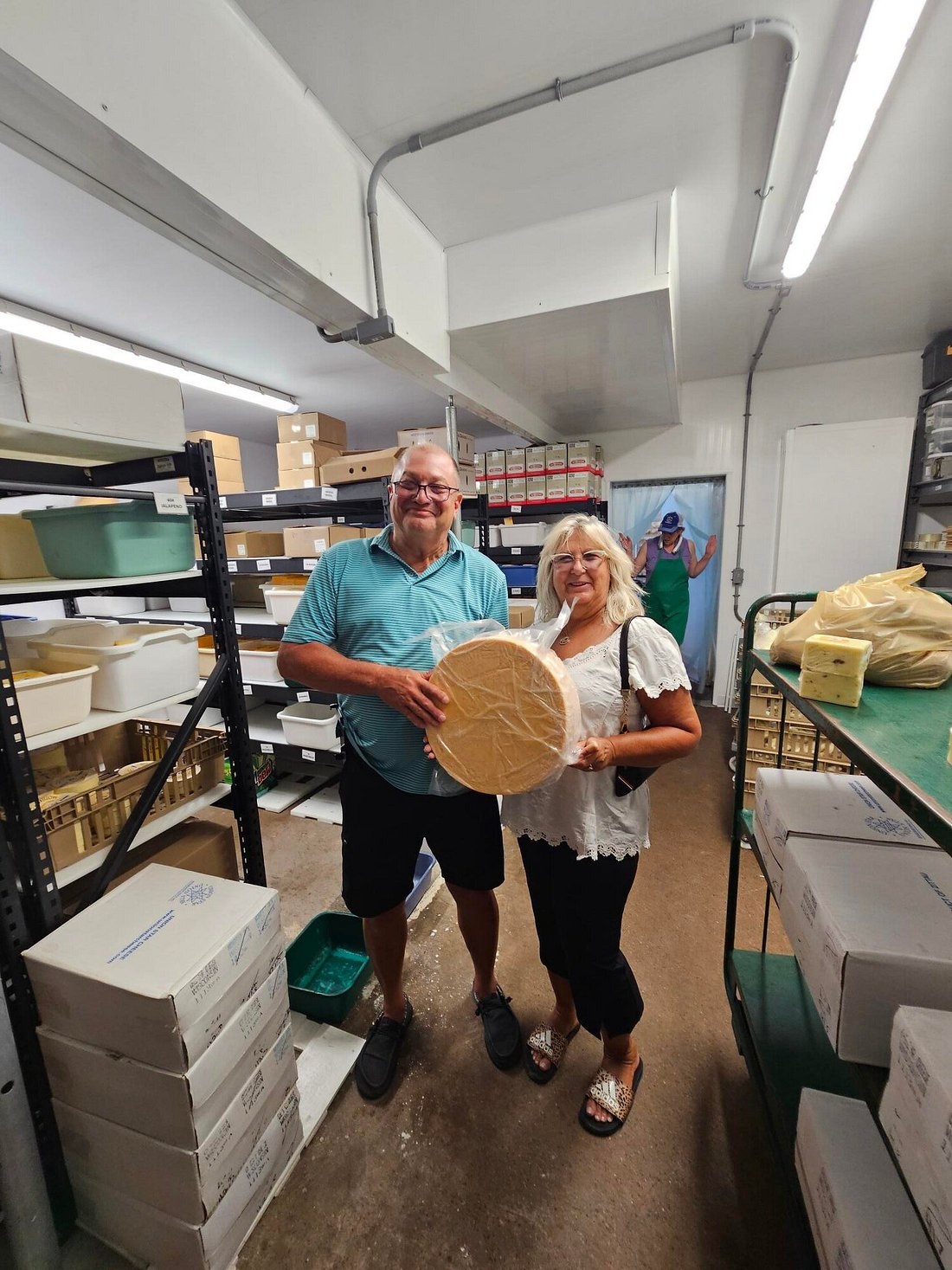 A visitor holding cheese beside a Union Star cheesemaker